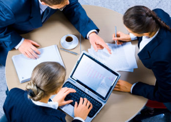 Image of three business people working at meeting