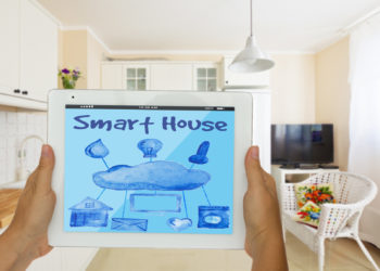 Smart house concept - hans holding tablet with remote control