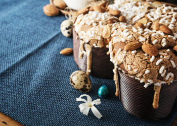 Colomba - italian easter dove cake on old rustic cyan wooden board. Selective focus, free text space.